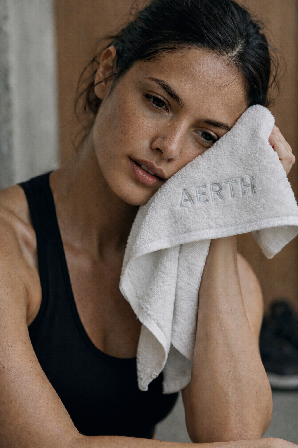 Femme dans une salle de sport qui s'essuie avec une serviette Aerth