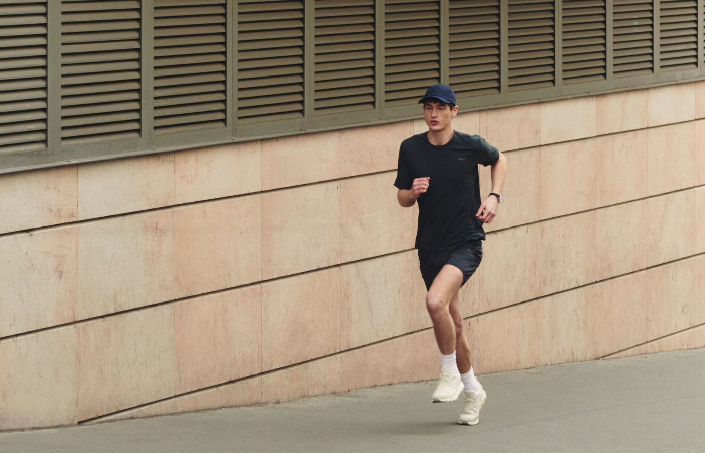 Homme qui court dans la rue avec une tenue Aerth 